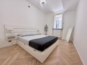 a white bedroom with a bed and a window at WANDERLUST Splendido appartamento in centro in Pavia