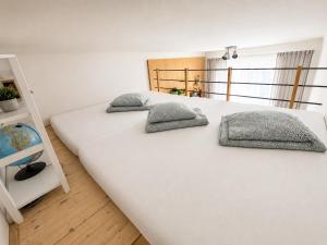 two pillows on a large white bed in a room at Like at home Brno - celý byt in Komárov