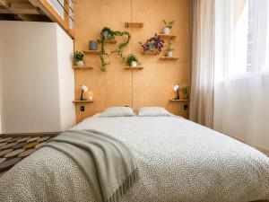 a bedroom with a large bed with plants on the wall at Like at home Brno - celý byt in Komárov +5 photos