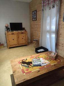 a coffee table with a book on it in a living room at Chez So et Compagnie in Saint-Gérand-de-Vaux