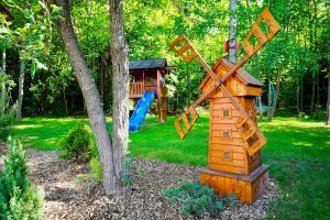 a wooden windmill sitting next to a playground at Chata na Zbojskej - Zbojská in Pohronská Polhora