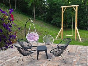 a group of chairs and a swing in a garden at Brvnara Floridita u prirodi - blizu Manastira Tavna in Ugljevik