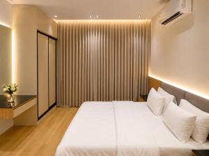 a bedroom with a large white bed with white pillows at Abha Elite Suites ابها ايليت سويتس in Abha