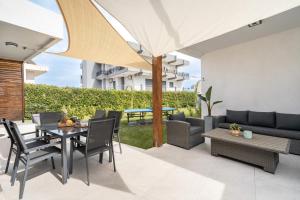 a patio with a table and chairs and an umbrella at Eldorado Luxury Villa in Afantou