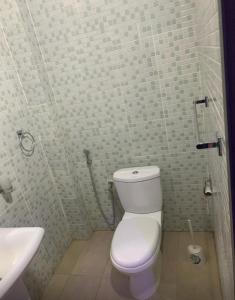 a bathroom with a white toilet and a sink at Immeuble Racine in Ngaparou