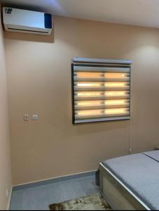 a bedroom with a window with a air conditioner at Immeuble Racine in Ngaparou