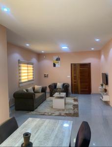 a living room with two couches and a tv at Immeuble Racine in Ngaparou