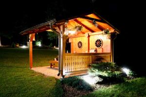 a bird house with a bench in a yard at night at Chata na Zbojskej - Zbojská in Pohronská Polhora