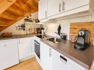 a kitchen with white cabinets and a sink at Alpintunet Uvdal in Sønstebø