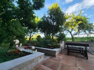 a garden with a bench and flowers and trees at Apartmaji I&E in Sežana