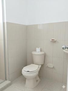 a bathroom with a toilet and a roll of toilet paper at Hotel Almirante Padilla in Ríohacha