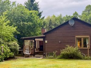 a brown house with a chair sitting outside of it at Bisamlodge in Faßberg +30 photos