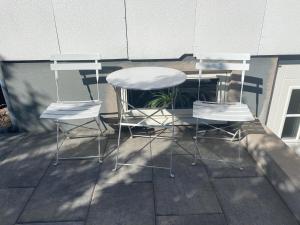two chairs and a table on a patio at Centralt Semesterboende in Halmstad