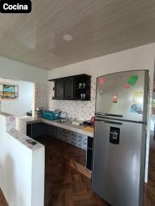 a kitchen with a stainless steel refrigerator and black cabinets at APARTAMENTOS LIZ MARIA in Coveñas