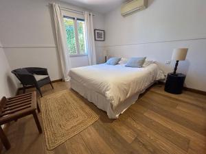 a bedroom with a bed and a chair and a window at Bastide le Petit Clos - les 2 Gîtes in Perpignan +79 photos