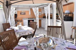 a dining room with tables and chairs and a kitchen at Kuća za odmor Nada in Marina