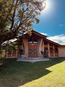 a house with a tree in front of it at Posada La Tregua in El Bolsón