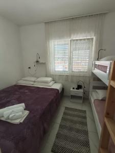 a bedroom with two beds and a bunk bed at Kuća za odmor Nada in Marina