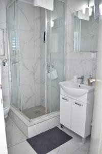 a white bathroom with a shower and a sink at Kuća za odmor Nada in Marina +101 photos