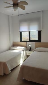 a bedroom with two beds and a ceiling fan at Apartamento Residencial Colinas del Golf, Envía, Almería in La Envia +22 photos