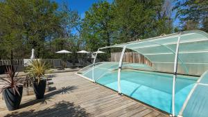 a swimming pool with a cover on a wooden deck at Chalets de vacances Castelwood in Biron