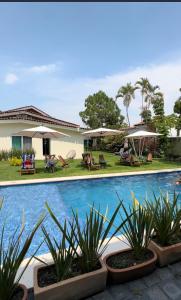 a swimming pool with plants in front of a house at Quinta Los Caballos in Ajijic