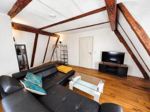 a living room with a black couch and a tv at Wohnung mit hist. Altstadt Charme in Nördlingen