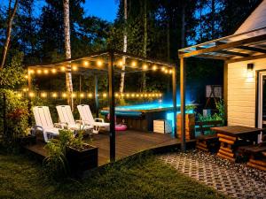 a deck with chairs and a swimming pool at night at Family Resort in Dziwnów