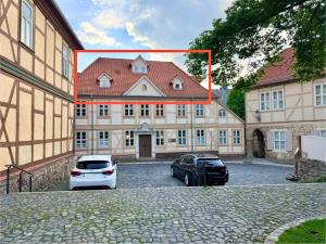 a building with two cars parked in front of it at HyggeLiving - 120qm - Boxspringbetten - 55" Smart TV - Küche - Parkplatz - bis 8 Pers - BESTLAGE in Wernigerode