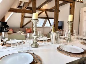 a table with plates and glasses on top of it at HyggeLiving - 120qm - Boxspringbetten - 55" Smart TV - Küche - Parkplatz - bis 8 Pers - BESTLAGE in Wernigerode