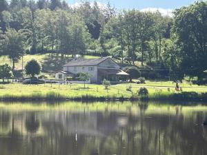 a house sitting next to a body of water at La petite lisonne in Marval +44 photos