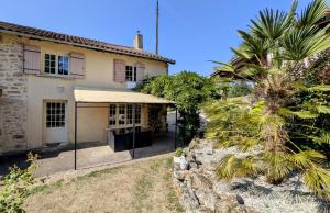 a house with a palm tree in front of it at La petite lisonne in Marval