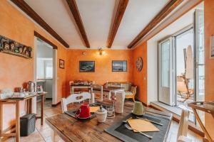 a living room with orange walls and a table and chairs at B&B Il Feriolo in Baveno