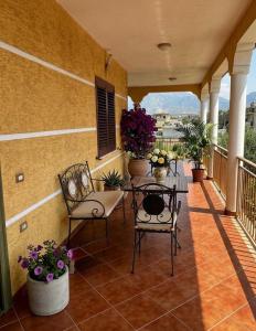 a porch with chairs and a table on a balcony at Colombo' s House in Shkodër