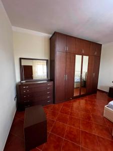 a bedroom with brown cabinets and a tiled floor at Colombo' s House in Shkodër