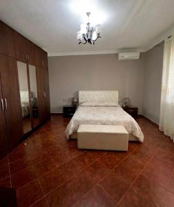 a bedroom with a bed and a chandelier at Colombo' s House in Shkodër