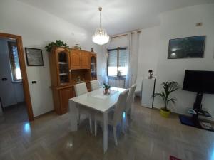 a dining room with a white table and chairs at Casa Stefy Gubbio in Gubbio