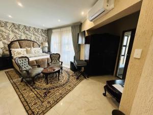 a bedroom with a bed and a table and chairs at Jul Rick House Guesthouse in Sandton