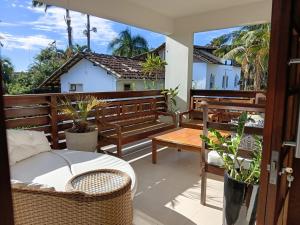a balcony with wooden benches and a table at Flat - SERRA E MAR - Paraty in Paraty