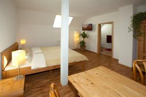 a bedroom with a bed and a table in a room at " Zum alten Schlawiner " in Orsingen-Nenzingen