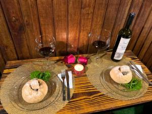 a table with two plates of food and a bottle of wine at Cenário Perfeito para Seu Dia Especial: Chácara Recanto do Pinheiro in Capão do Leão