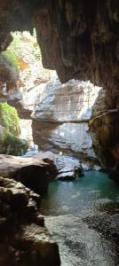 a cave with a pool of water in a canyon at Кирч Горис in Goris +26 photos