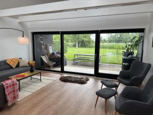 a living room with a couch and a table at Sortehus - 100 steps from the finest beach in Vallebo