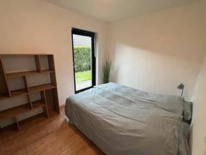 a bedroom with a bed and a window at Sortehus - 100 steps from the finest beach in Vallebo