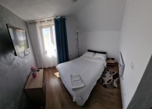 a bedroom with a large white bed and a window at Casa Loredana in Cârțișoara