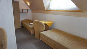 a room with two beds and a table and a window at Wiktorowa Chata in Wierchomla Wielka