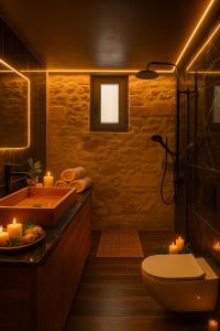 a bathroom with a tub and a toilet and candles at ArKa in Chania