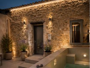 a stone building with a swimming pool in front of it at ArKa in Chania