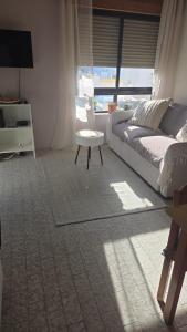 a bedroom with a bed and a table and a window at Appartement PRIMAVERA in Armação de Pêra