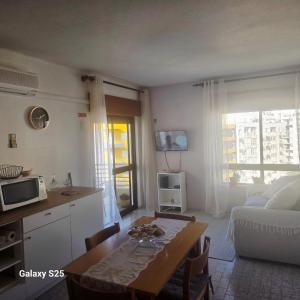 a kitchen and a living room with a table and a couch at Appartement PRIMAVERA in Armação de Pêra